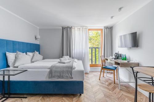 a hotel room with a bed and a desk at Willa Letnia Apartamenty in Krynica Morska