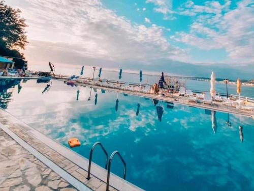 a large swimming pool with chairs and the water at Villa Amos at Aquamarine Residence in Vlorë