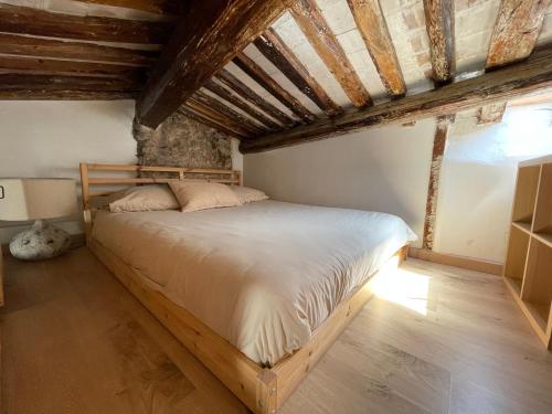 a bedroom with a bed in a room with wooden ceilings at appartement du pêcheur à Cassis à 10 mètres du port in Cassis