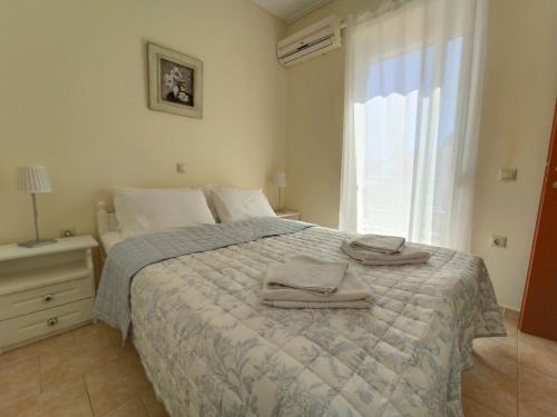 a bedroom with a bed with two towels on it at Kalamaki Court Villas in Kalamaki
