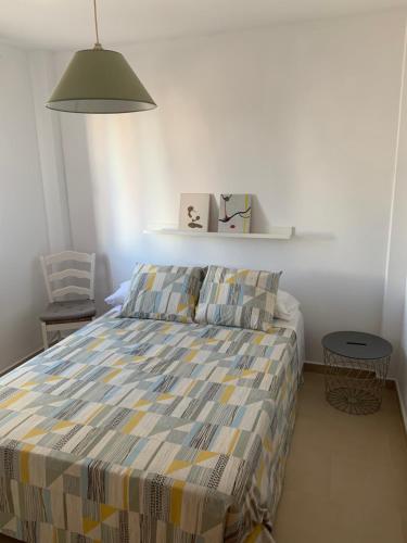 a bedroom with a bed with a striped comforter at Apartamento a pie de playa in Tarifa