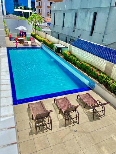 an overhead view of a swimming pool with chaise lounge chairs at Beira Mar Imperial Flat 612 in João Pessoa