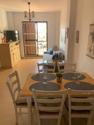 a dining room with a table and chairs and a living room at Apartamento a pie de playa in Tarifa