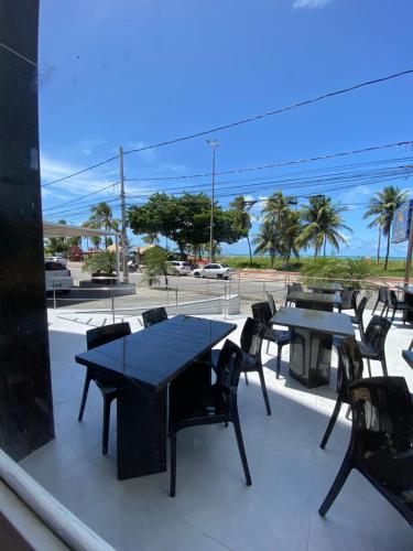 a patio with tables and chairs and a view of a street at Beira Mar Imperial Flat 612 in João Pessoa