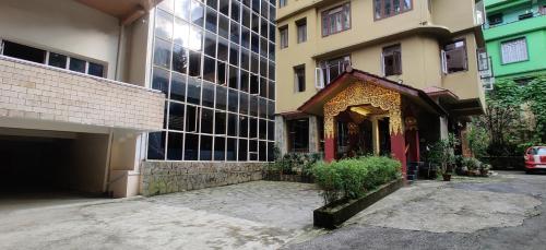 un edificio accanto a un alto edificio con ingresso di HOTEL RENDEZVOUS a Gangtok