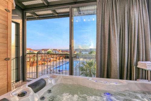 a bath tub in a room with a large window at Apartman "TURANJ" in Turanj