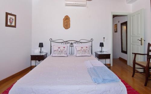 a bedroom with a large white bed with pink pillows at Stella's traditional house. in Alonnisos Old Town