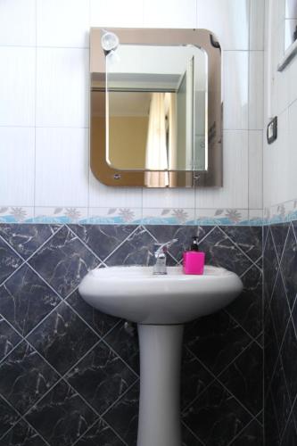 a bathroom with a sink and a mirror at Shtepi Pushimi in Durrës