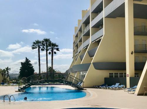 a large hotel with a swimming pool next to a building at Condo do Mar Lovely first floor apartment with pool in Lagos