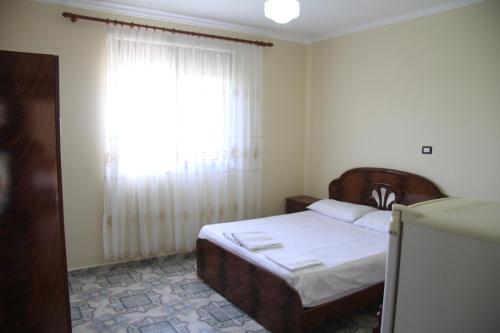 a bedroom with a bed and a large window at Shtepi Pushimi in Durrës