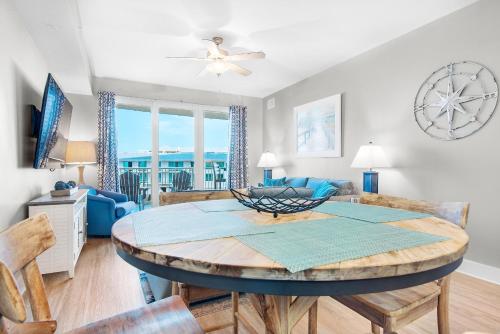 a dining room and living room with a table and chairs at Calypso 3-406 - Paradise by the Pier in Panama City Beach