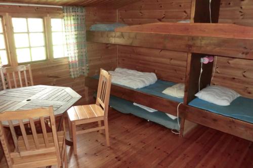 Pokój z 2 łóżkami piętrowymi i stołem w obiekcie Backgårdens Stugby w mieście Axvall