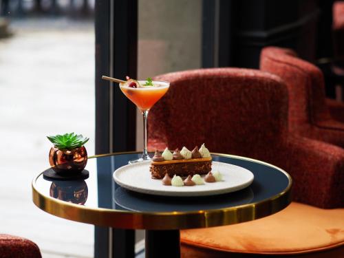 a table with a plate of food and a drink at Hôtel De Wimereux in Wimereux