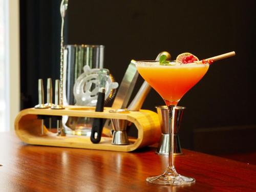 a cocktail sitting on a wooden table next to a juicer at Hôtel De Wimereux in Wimereux
