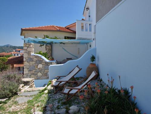 a pair of chairs sitting on the side of a house at Stella's traditional house. in Alonnisos Old Town