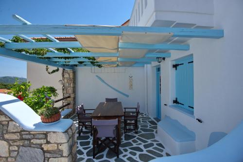 a patio with a table and chairs under a pergola at Stella's traditional house. in Alonnisos Old Town