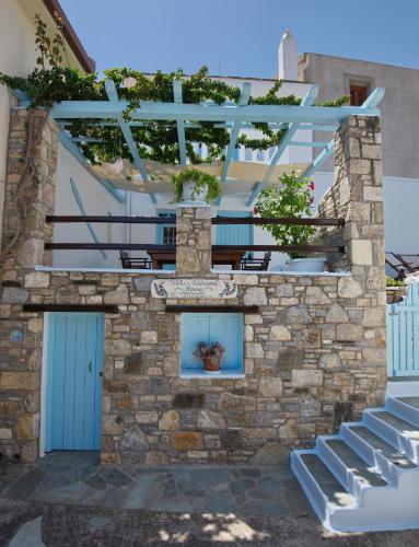 a building with a blue door and a stone wall at Stella's traditional house. in Alonnisos Old Town