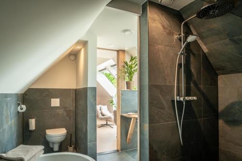 a bathroom with a shower and a toilet at Wijngaard de Kroon van Texel in Den Burg