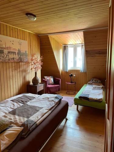 Un dormitorio con 2 camas y una silla. en Chata Vrch Varta en Ružomberok