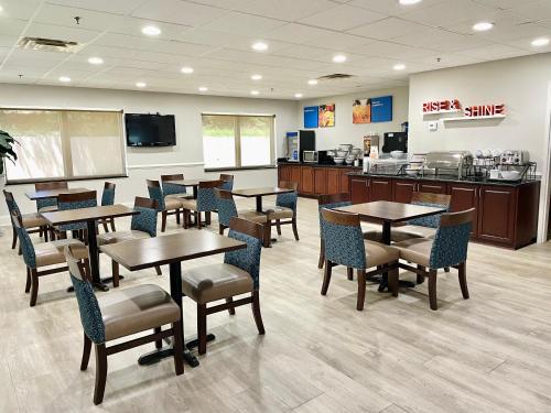 a restaurant with tables and chairs and a kitchen at Comfort Inn & Suites Augusta Fort Eisenhower Area in Augusta