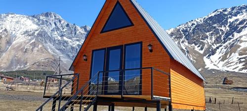 a small house in front of a mountain at KAZBEGI COMPASS in Stepantsminda