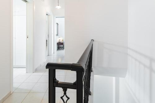 a black chair in a hallway with a white wall at Haris Villas in Keratokampos