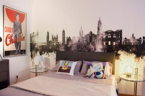 a bedroom with a bed with a black and white city mural at MalagaOlé Centro in Málaga