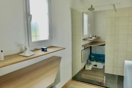 La salle de bains est pourvue d'un lavabo, d'une fenêtre et d'un miroir. dans l'établissement Villa de plain pied avec BBQ et piscine, à Tavernes