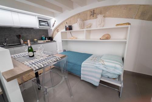 eine kleine Küche mit einem Tisch und einer Flasche Wein in der Unterkunft Ortigia Charme piazza Duomo in Syrakus