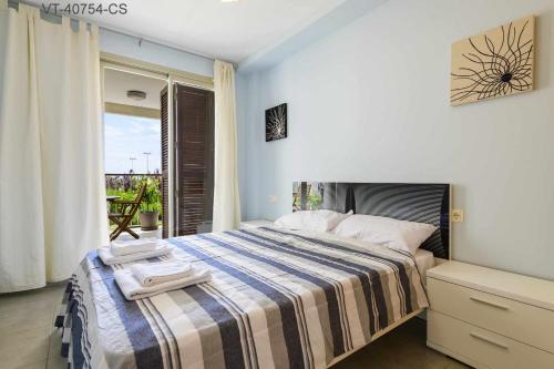 a bedroom with a bed with a striped blanket at Apartamento en Residencial Aldea Golf Panorámica in San Jorge