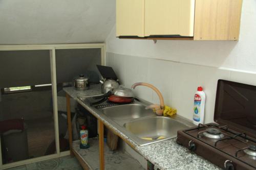 a kitchen with a sink and a counter top at Shtepi Pushimi in Durrës