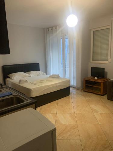 a small room with a bed and a kitchen at Kokomani in Durrës