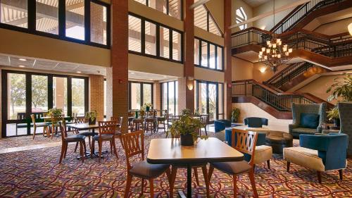 a large lobby with tables and chairs and windows at Inn at Coushatta in Kinder