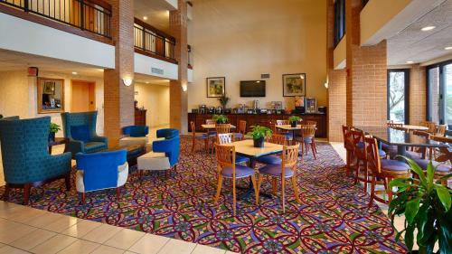 a lobby with tables and chairs in a hotel at Inn at Coushatta in Kinder