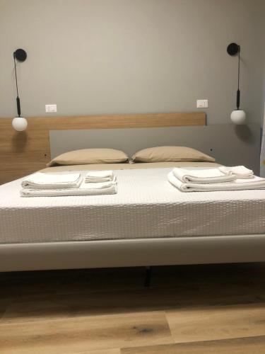 a bed with two white towels on top of it at A Due Passi Dalla Scalinata Rooms in Caltagirone