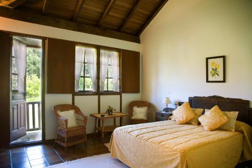 a bedroom with a bed and a table and windows at Casa Rural Cordobelas in Cedeira
