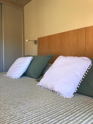 Una cama con dos almohadas encima. en ALIWEN Rauli en San Martín de los Andes