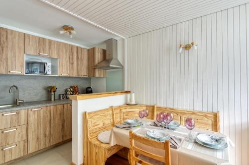 une cuisine avec une table avec des verres à vin dessus dans l'établissement Le Petit Balcon avec vue sur le Mont-Blanc 2 étoiles, à Chamonix-Mont-Blanc