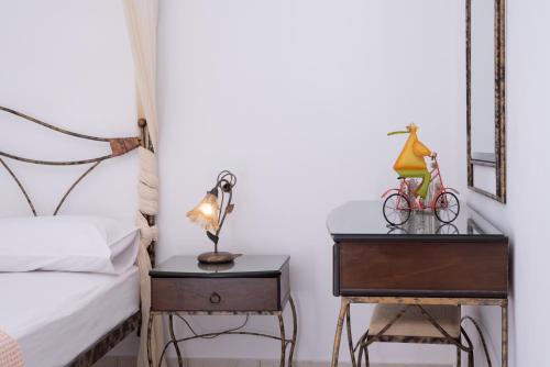 a bedroom with a bed and a table with a lamp at Haris Villas in Keratokampos