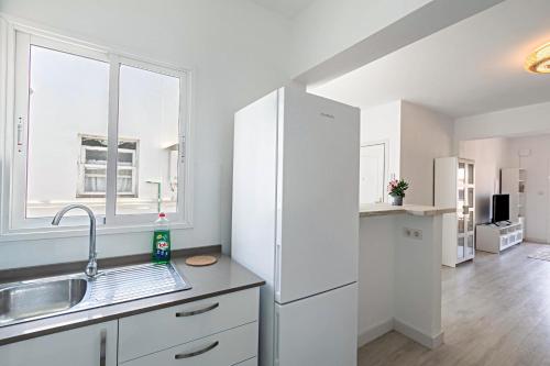 a kitchen with a white refrigerator and a window at Apartment City Lounge in Santa Cruz de Tenerife