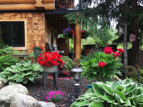 um jardim com flores e plantas em frente a um edifício em A Suite Retreat - Beyond Bed & Breakfast em Sun Peaks