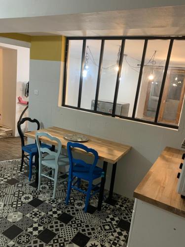 - une table à manger avec 2 chaises, une table et des fenêtres dans l'établissement Maison spacieuse et familiale, à Pexonne