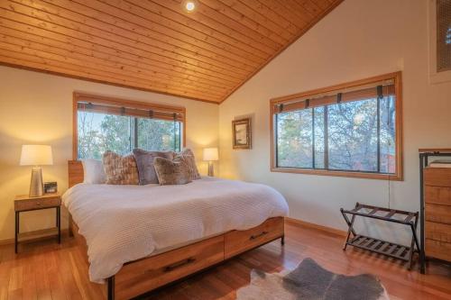a bedroom with a large bed and two windows at STARGAZER-Your Luxurious Cozy Affordable Getaway in Sugarloaf