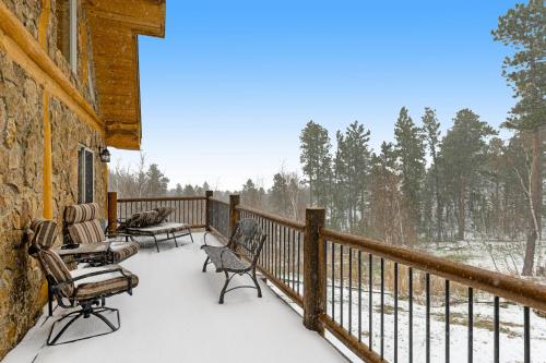 a covered porch with chairs and a snow covered at Tetro Rock Retreat in Deadwood