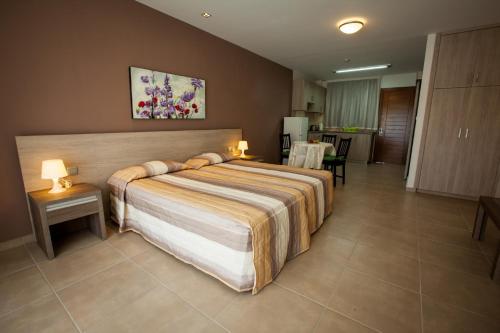 a hotel room with a bed and two tables and chairs at Crystallo Apartments in Paphos
