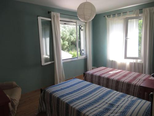 1 dormitorio con 2 camas y ventana en George's house en Giannádes
