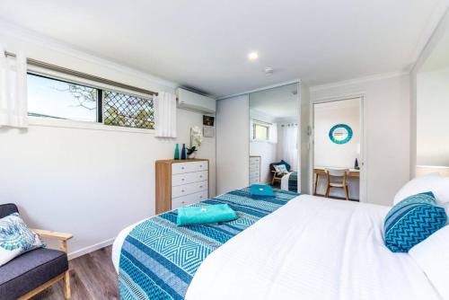 a bedroom with a bed and a chair and a window at Central Location - Noosa Address - Pet Friendly in Noosa Heads