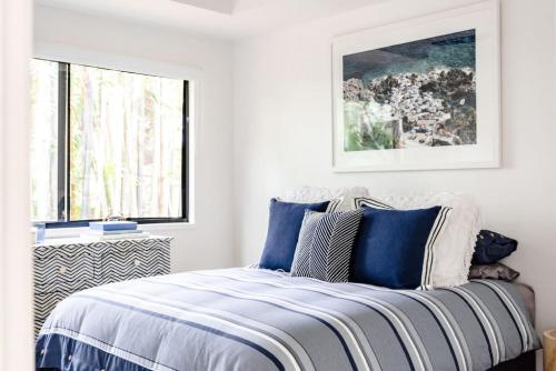 a bedroom with a bed with blue and white pillows at BERRIMA LUXE - Noosa Hill Home - Heated Pool in Noosa Heads
