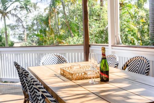 a bottle of wine sitting on a table with chairs at BERRIMA LUXE - Noosa Hill Home - Heated Pool in Noosa Heads