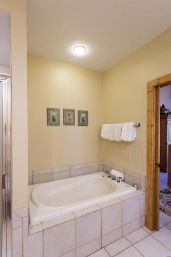 a large bath tub in a bathroom with yellow walls at Interlachen Unit 4 in Nisswa